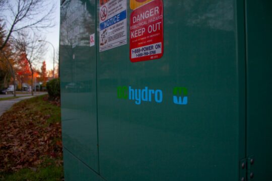 a green metal box with a sign on it